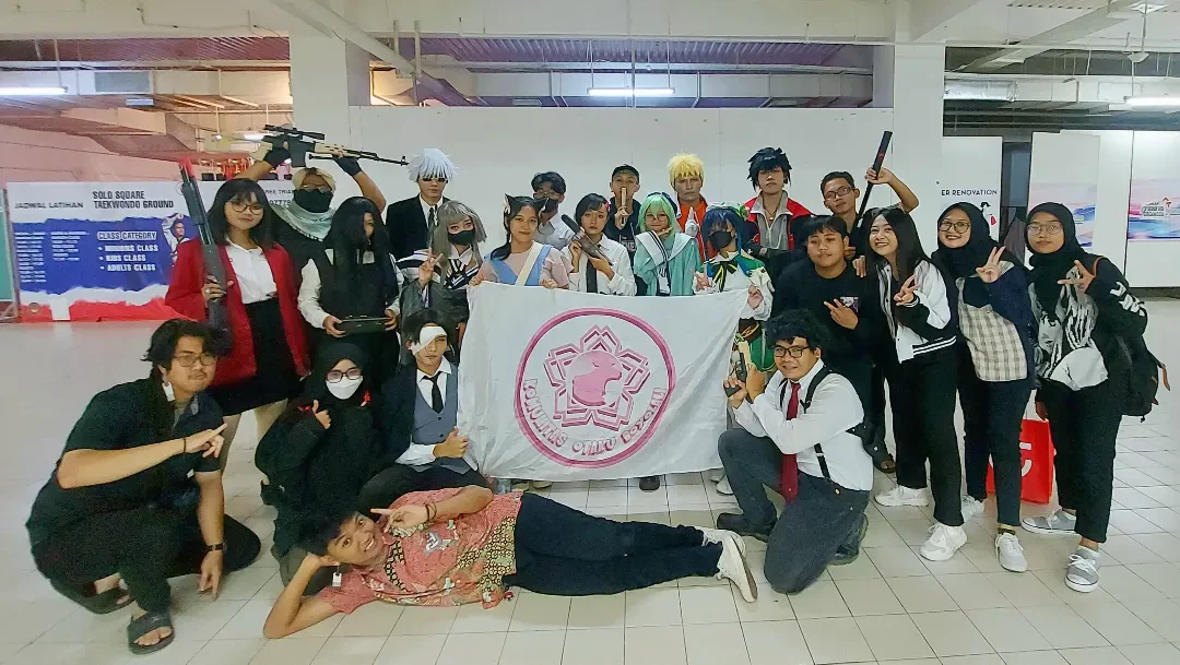 Anggota komunitas membentangkan bendera KOBOY di dalam gedung